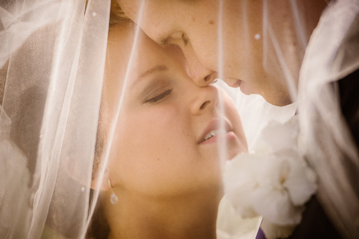 En bruds och en brudgums ansikten under en slöja